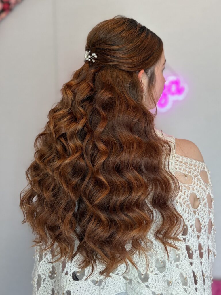 Bridal model with a deep ginger half-up half-down style with fluffy curls and a pinned floral ornamental detail in the back. Styled by Jaya Ronquillo at the Belleza Bridal studio in Ann Arbor Michigan.