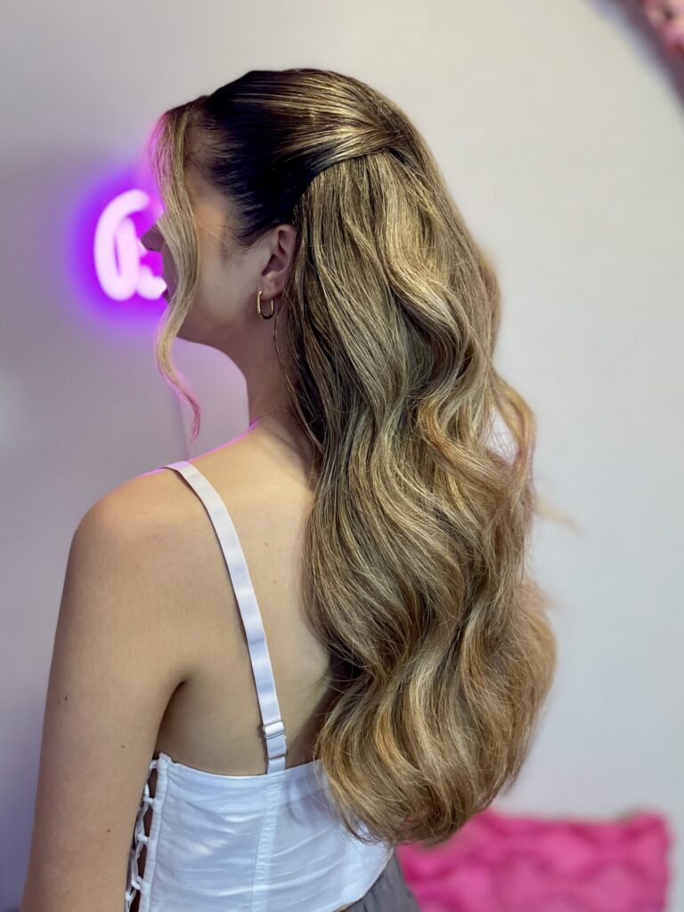 Bridal model with a dirty blonde half-up half-down style with loose curls, face framing, and pinned back curls. Styled by Jaya Ronquillo at the Belleza Bridal studio in Ann Arbor Michigan.