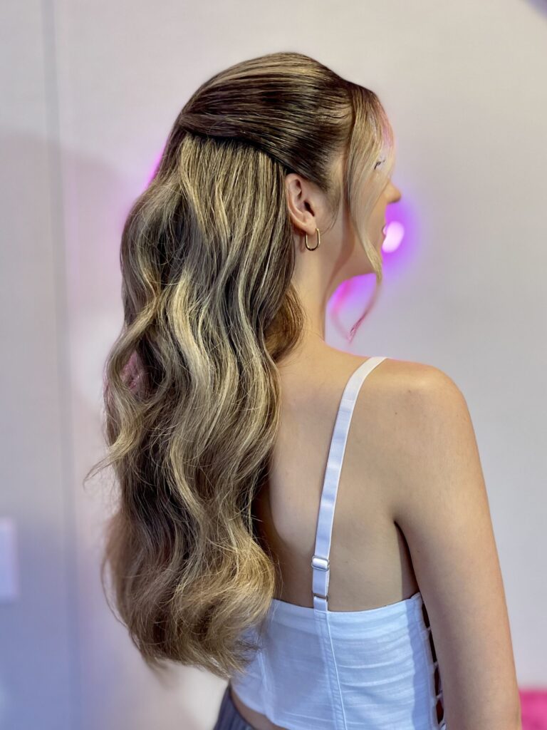 Bridal model with a dirty blonde half-up half-down style with loose curls, face framing, and pinned back curls. Styled by Jaya Ronquillo at the Belleza Bridal studio in Ann Arbor Michigan.
