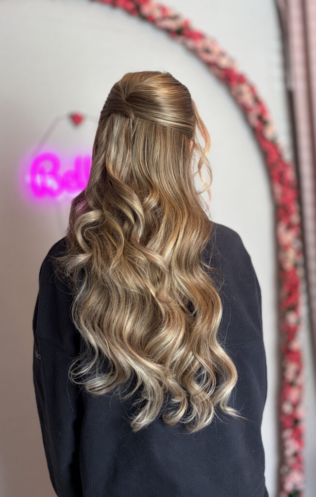 Bridal model with a long blonde half-up half-down curly style. Hair is shiny and glowy with loose curls. Styled by Jaya Ronquillo at the Belleza Styles studio in Ann Arbor Michigan. 