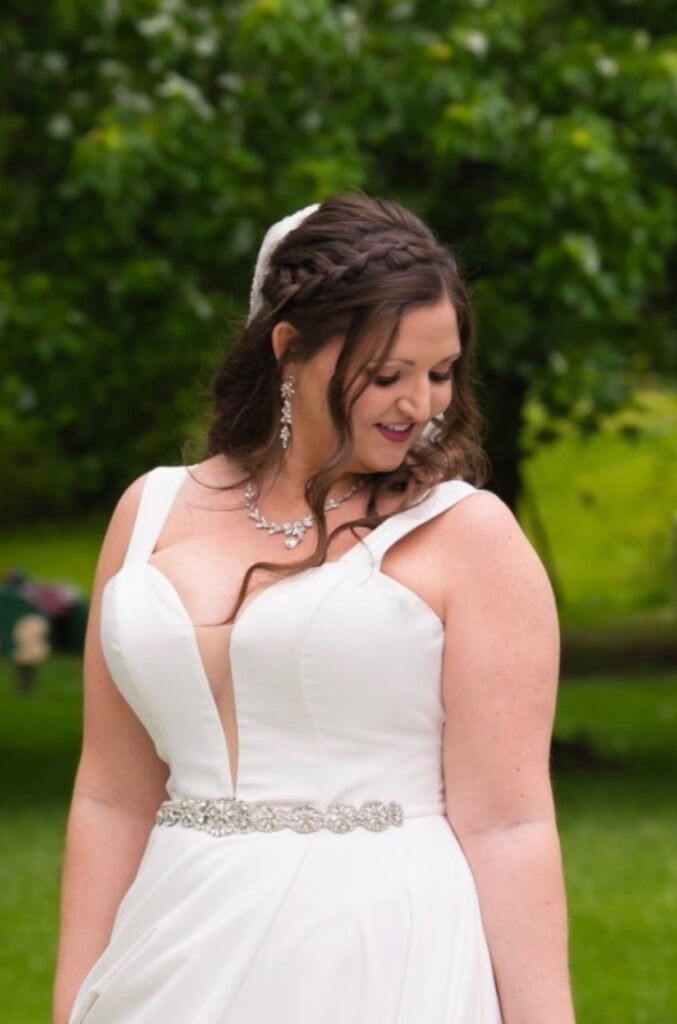Bride wit brunette braided crown over long curls and face framing. 