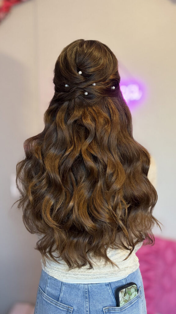 Bridal model with a brunette half-up half-down style with twisted curls and a braided feature with pearl details. Styled by Jaya Ronquillo at the Belleza Bridal studio in Ann Arbor Michigan.