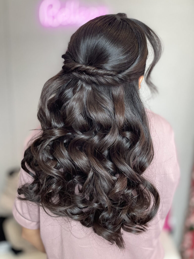 Bridal model with a long black half-up half-down curly style. Hair is shiny and glowy with loose curls, and a waterfall braid. Styled by Jaya Ronquillo at the Belleza Styles studio in Ann Arbor Michigan. 