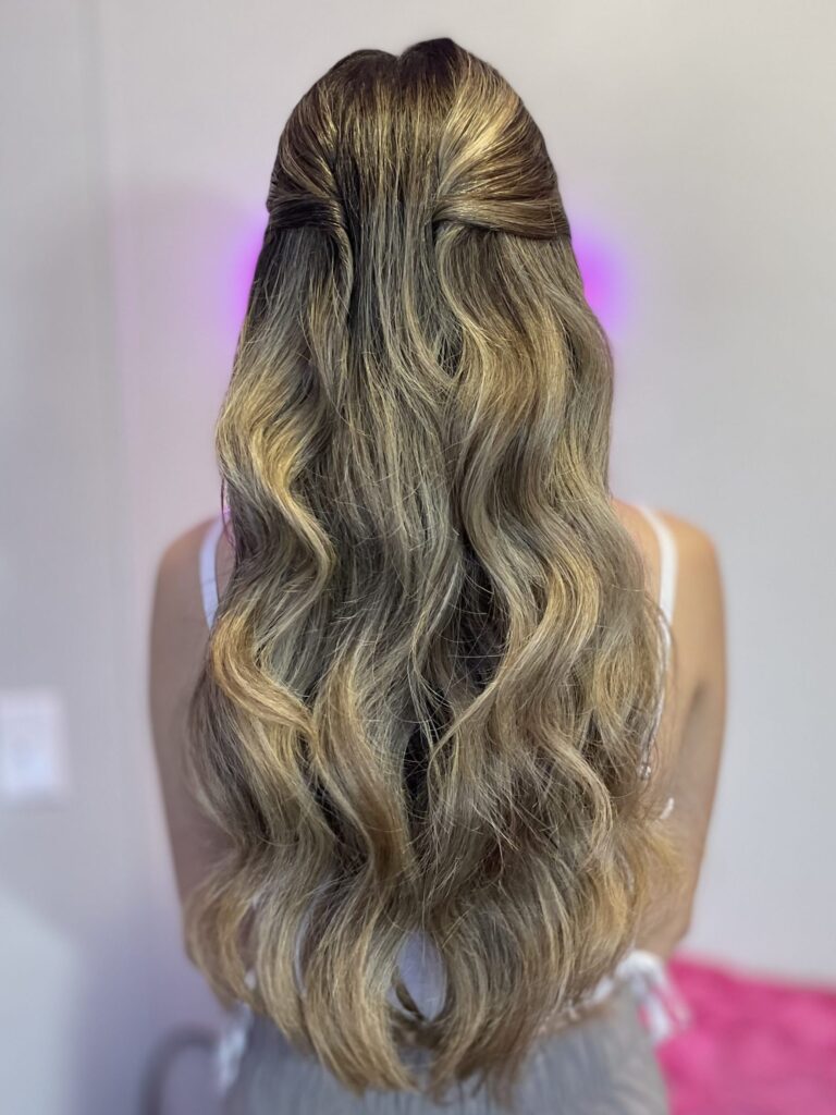 Bridal model with a dirty blonde half-up half-down style with loose curls, face framing, and pinned back curls. Styled by Jaya Ronquillo at the Belleza Bridal studio in Ann Arbor Michigan.