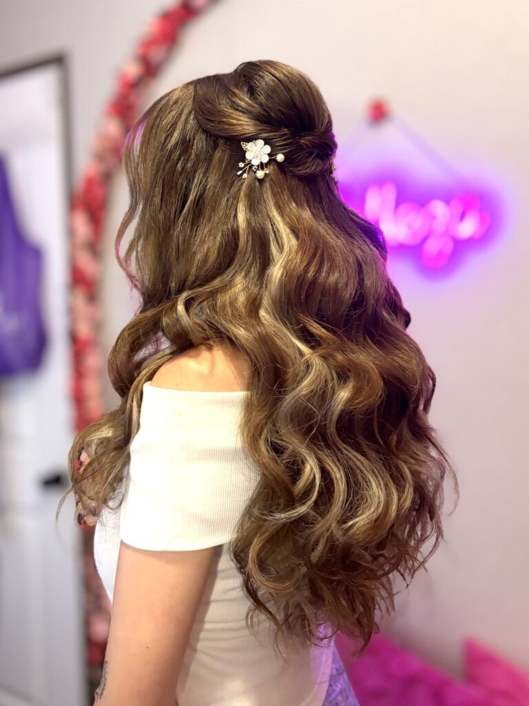 half-up half-down style with fluffy curls and twisted details along the crown. High volume curls on dirty blonde hair with golden highlights and floral ornamental pins. Styled by Jaya Ronquillo at the Belleza home studio in Washtenaw County Michigan