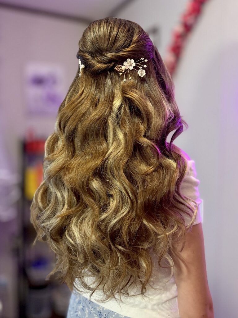 half-up half-down style with fluffy curls and twisted details along the crown. High volume curls on dirty blonde hair with golden highlights and floral ornamental pins. Styled by Jaya Ronquillo at the Belleza home studio in Washtenaw County Michigan