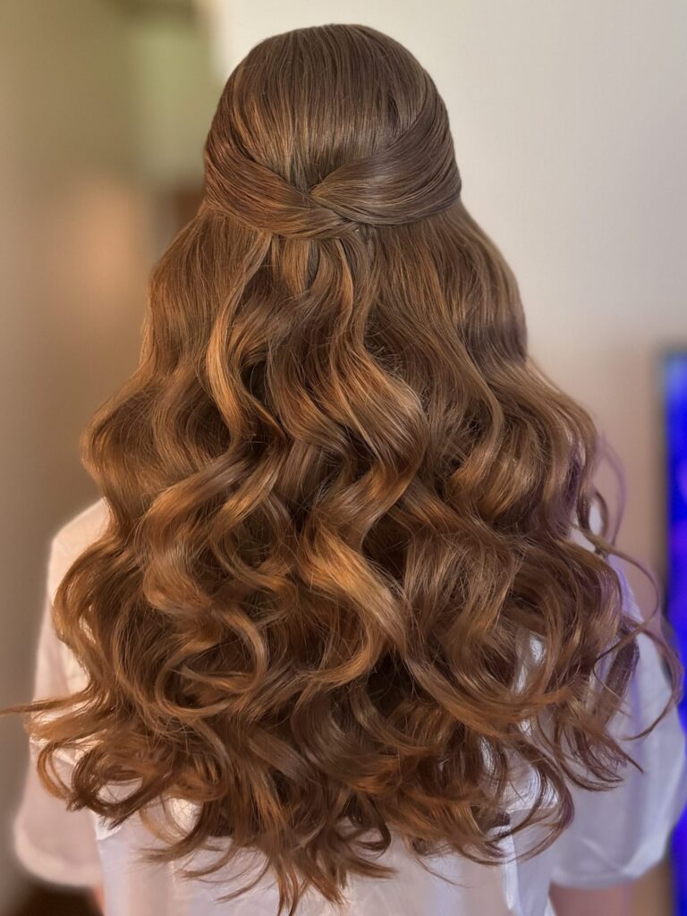 Bridal model with a deep ginger half-up half-down style with fluffy curls and a twisted detail in the back. Styled by Jaya Ronquillo at the Belleza Bridal studio in Ann Arbor Michigan.