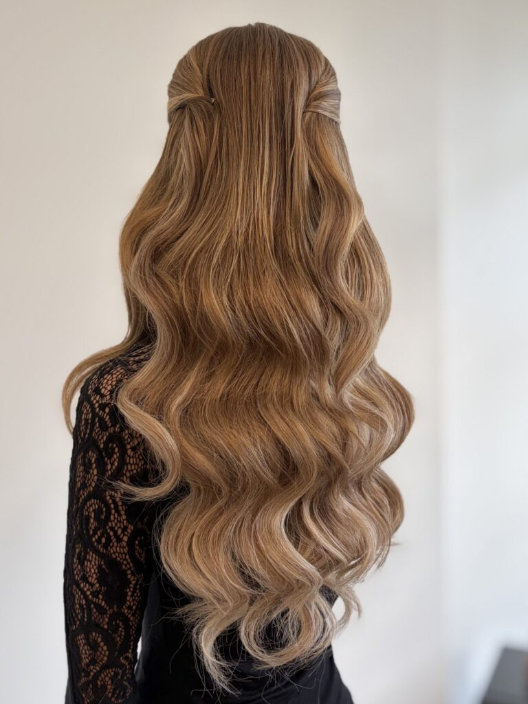 Bridal model with a dirty blonde half-up half-down style with loose curls, face framing, and pinned back curls. Styled by Jaya Ronquillo at the Belleza Bridal studio in Ann Arbor Michigan.
