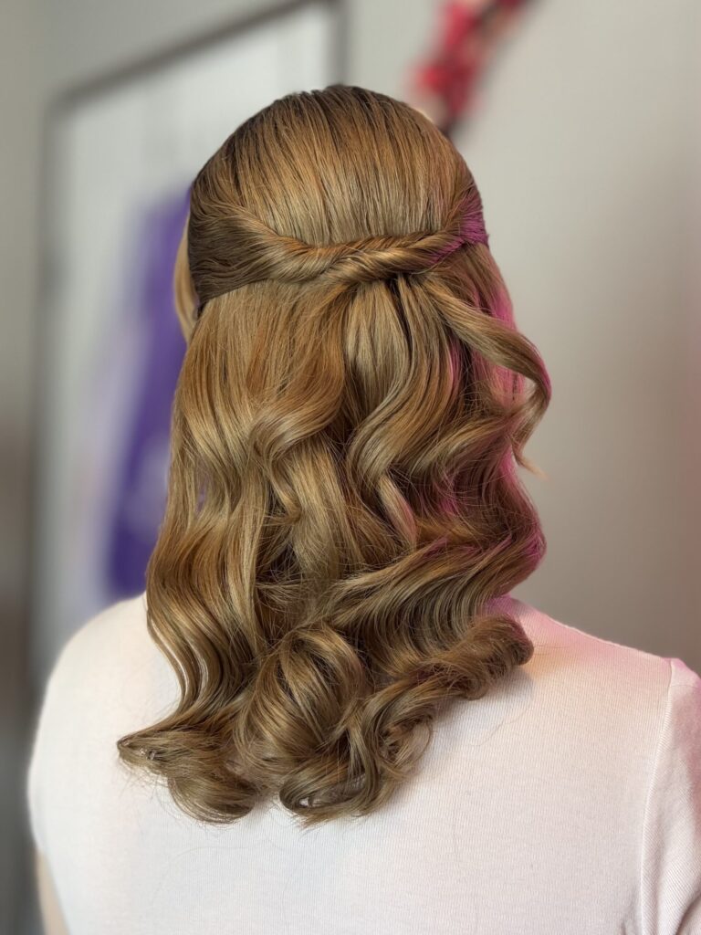 Bridal model with a mid length blonde half-up half-down curly style. Hair is shiny and glowy with loose curls. Styled by Jaya Ronquillo at the Belleza Styles studio in Ann Arbor Michigan. 