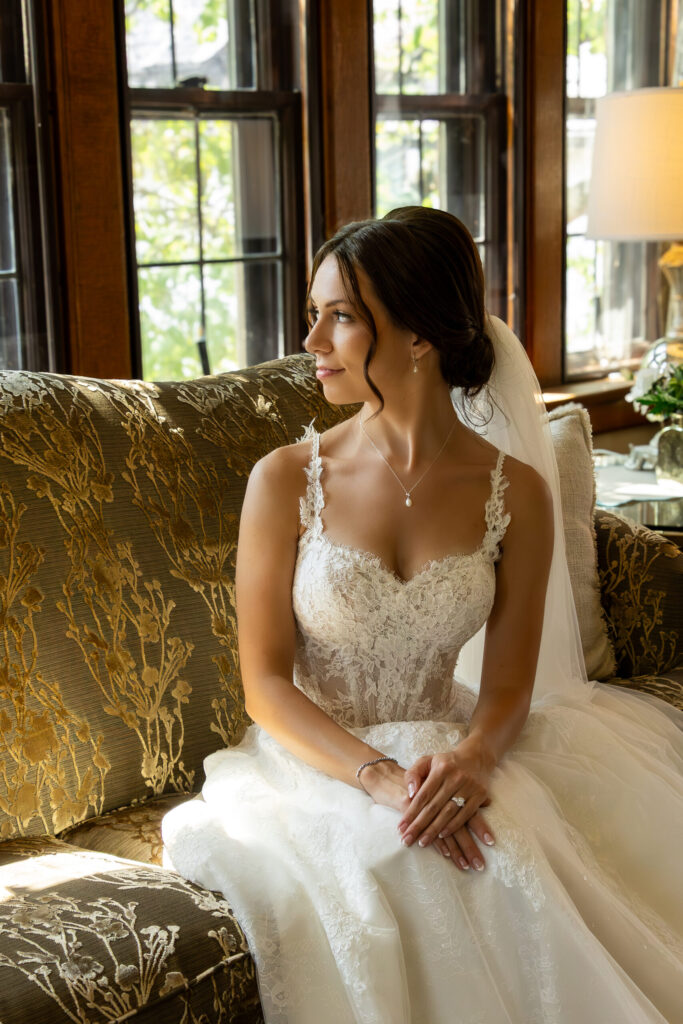 Bride with brunette low updo in a bun wit curled face framing pieces.
