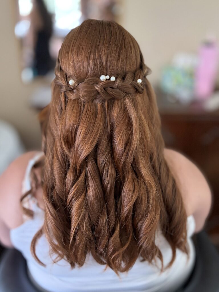 Bridal model with a deep ginger / auburn half-up half-down style with twisted curls and a braided feature with pearl details. Styled by Jaya Ronquillo at the Belleza Bridal studio in Ann Arbor Michigan.