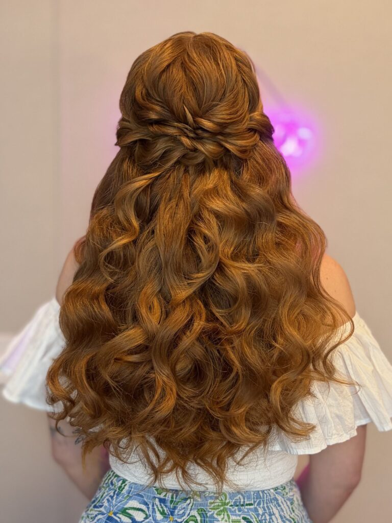 Bridal model with a deep ginger half-up half-down style with fluffy curls and a braided detail in the back. Styled by Jaya Ronquillo at the Belleza Bridal studio in Ann Arbor Michigan.